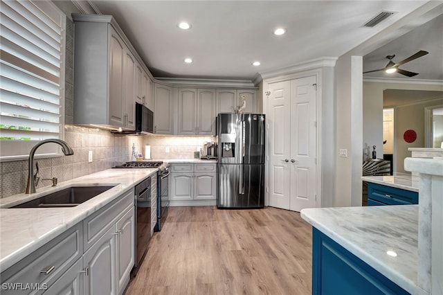 kitchen with visible vents, light stone counters, gray cabinets, black appliances, and a sink