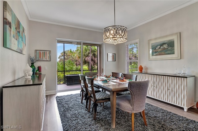 dining room with a notable chandelier, crown molding, and wood finished floors