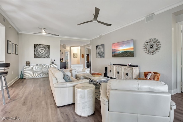 living area with ceiling fan, ornamental molding, wood finished floors, and visible vents