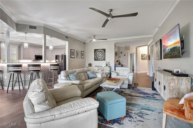 living room featuring visible vents, crown molding, and wood finished floors