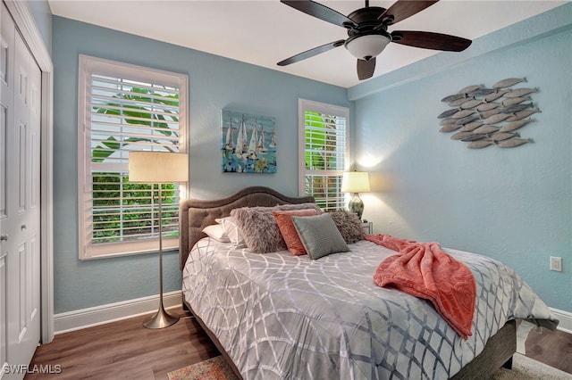 bedroom with baseboards, a ceiling fan, a textured wall, wood finished floors, and a closet