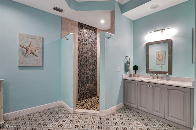 full bathroom with visible vents, vanity, baseboards, and walk in shower