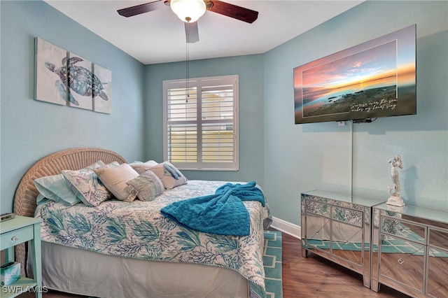 bedroom featuring ceiling fan, baseboards, and wood finished floors