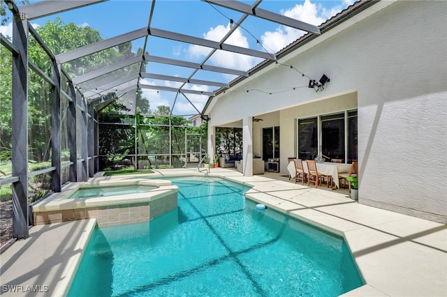 view of swimming pool with a patio, a lanai, and an in ground hot tub