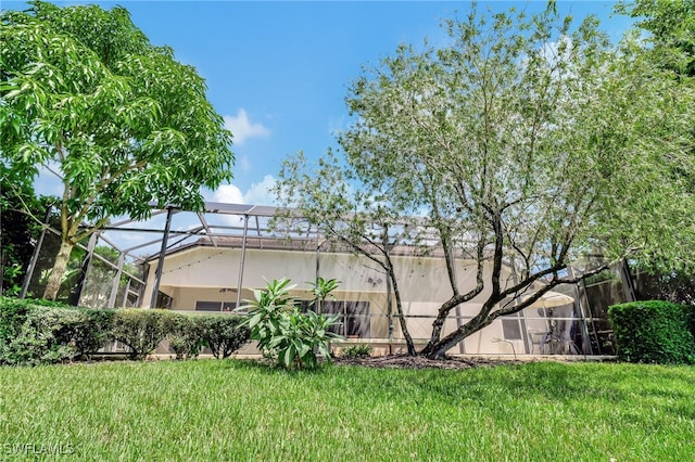 exterior space featuring a lanai and a lawn