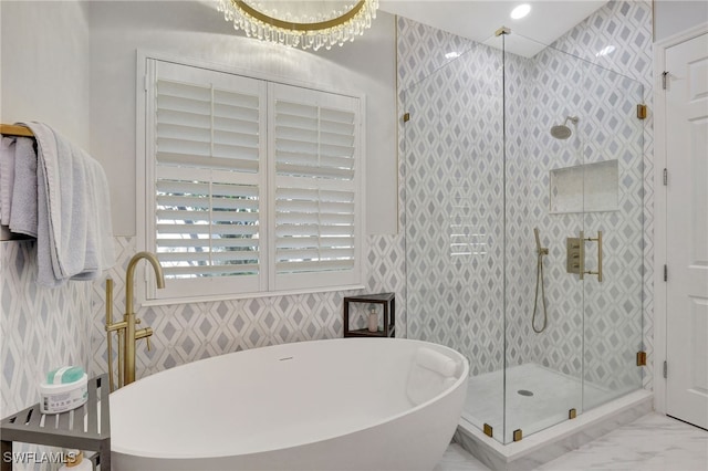 bathroom featuring shower with separate bathtub, a notable chandelier, and tile patterned floors