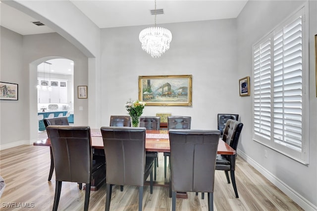 dining area featuring an inviting chandelier and light hardwood / wood-style floors