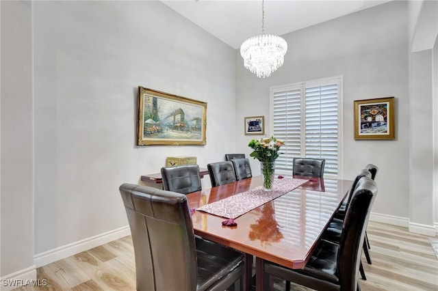 dining area with light hardwood / wood-style flooring and a notable chandelier