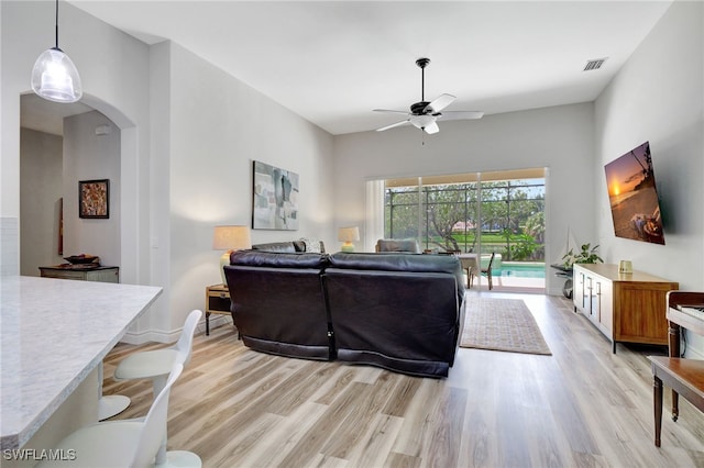 living room with ceiling fan and light hardwood / wood-style floors