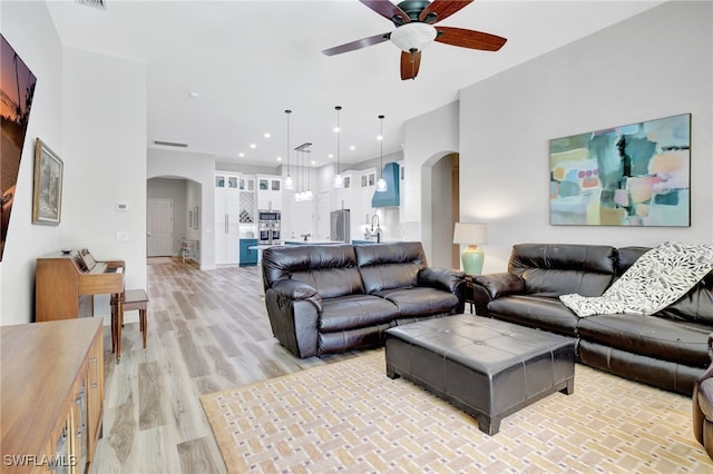 living room featuring ceiling fan and light hardwood / wood-style floors