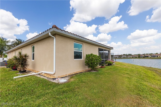 view of home's exterior featuring a lawn and a water view