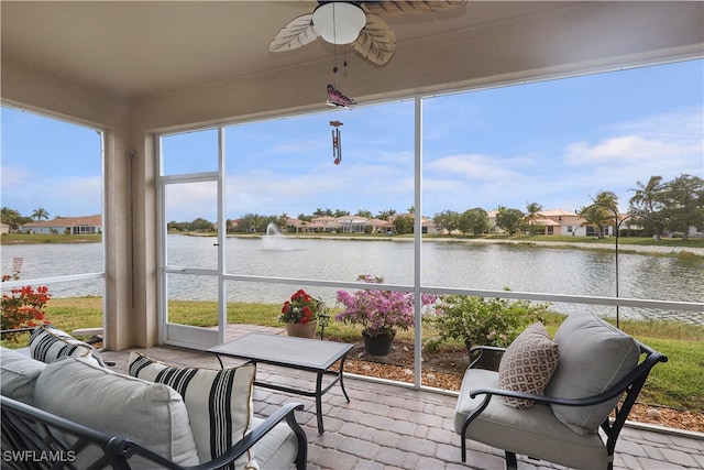 sunroom / solarium featuring ceiling fan, a wealth of natural light, and a water view