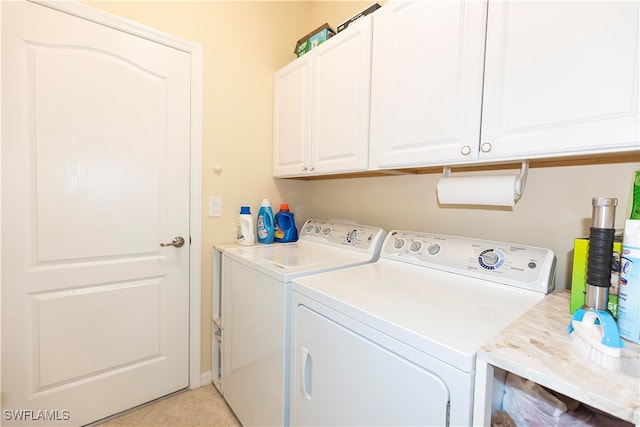 laundry room with cabinets, independent washer and dryer, and light tile patterned floors