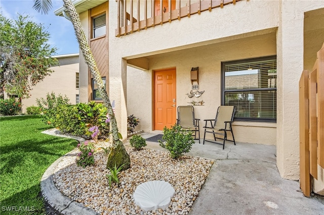 doorway to property featuring a balcony and stucco siding