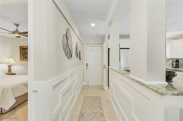 hall with light tile patterned floors, recessed lighting, a decorative wall, and wainscoting