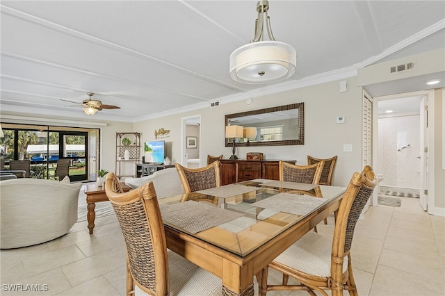 tiled dining room with ceiling fan and ornamental molding