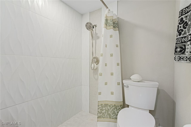 bathroom featuring toilet and a tile shower