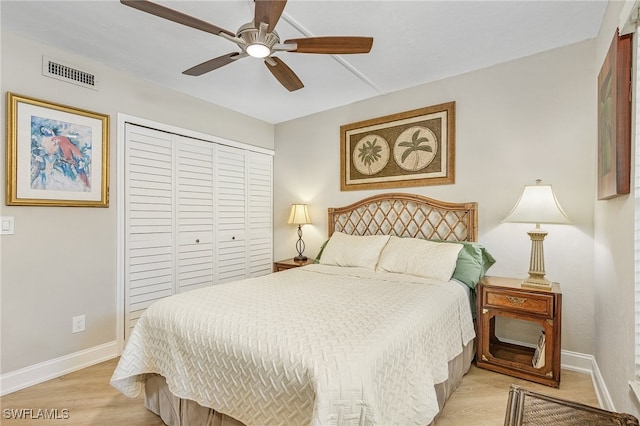 bedroom with a closet, light hardwood / wood-style flooring, and ceiling fan