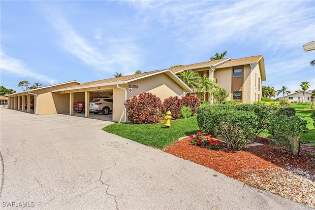 view of front of house featuring a front lawn and a carport