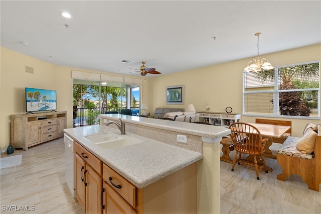 kitchen featuring sink, a center island with sink, ceiling fan with notable chandelier, and a wealth of natural light