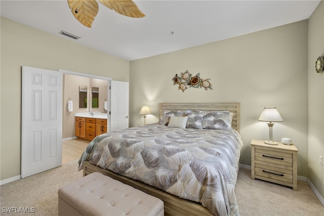 bedroom featuring ceiling fan, connected bathroom, and light colored carpet