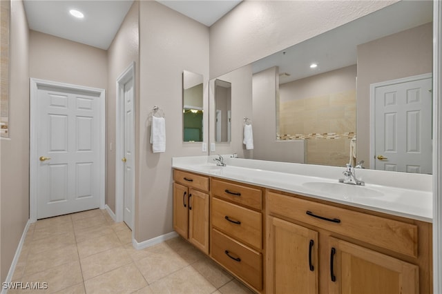 bathroom featuring tile patterned floors, a tile shower, and vanity