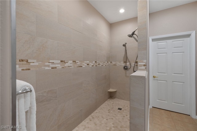 bathroom featuring tile patterned flooring and a tile shower