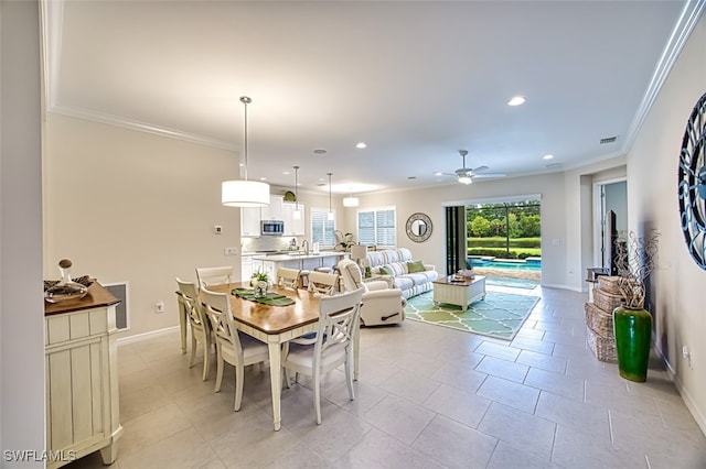 tiled dining space with ceiling fan and crown molding