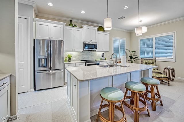 kitchen with an island with sink, sink, white cabinets, and stainless steel appliances