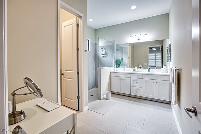 bathroom with tile patterned flooring, vanity, and tiled shower