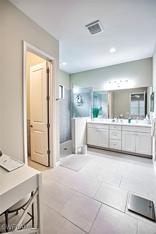 bathroom featuring tile patterned floors, vanity, and tiled shower