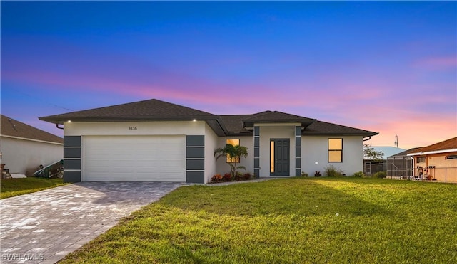 view of front of home featuring a lawn and a garage