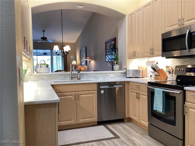 kitchen featuring pendant lighting, appliances with stainless steel finishes, sink, and decorative backsplash