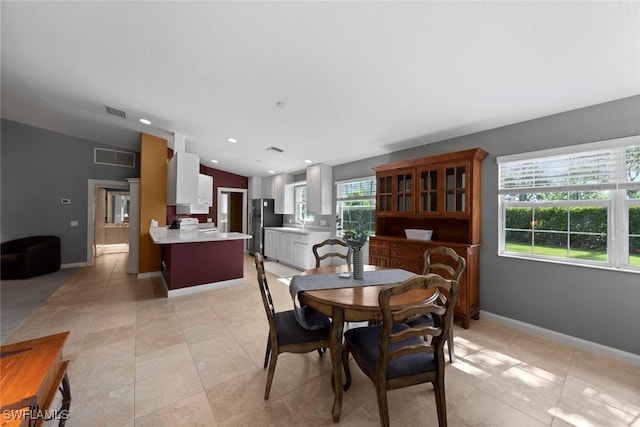 dining area with vaulted ceiling and light tile patterned floors