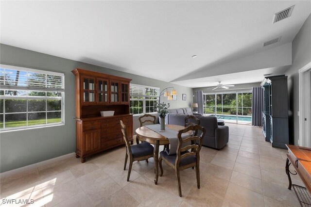 tiled dining room featuring lofted ceiling, a healthy amount of sunlight, and ceiling fan