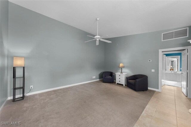 unfurnished living room with high vaulted ceiling, ceiling fan, and light carpet