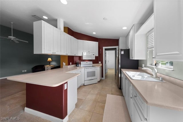 kitchen featuring white appliances, white cabinets, sink, a kitchen bar, and kitchen peninsula