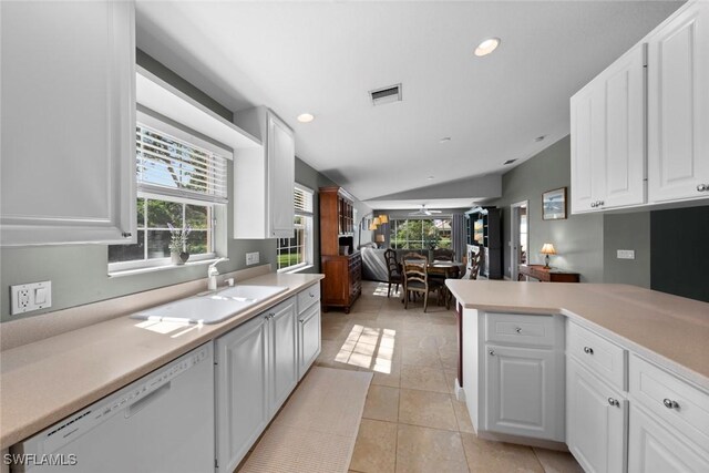 kitchen with lofted ceiling, white cabinets, white dishwasher, and sink