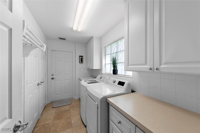 laundry area featuring independent washer and dryer and cabinets