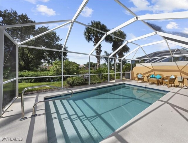 view of swimming pool featuring a patio area and a lanai