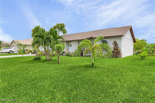 view of front of house with driveway, an attached garage, a front lawn, and stucco siding