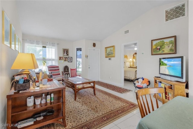 living room featuring lofted ceiling, light tile patterned flooring, and visible vents