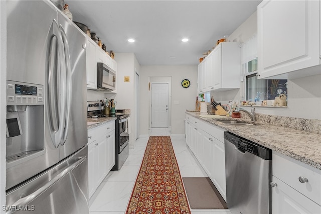 kitchen featuring white cabinets, sink, light stone countertops, and stainless steel appliances