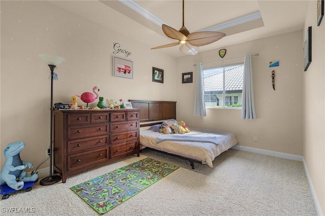 bedroom featuring ornamental molding, a tray ceiling, carpet floors, and baseboards