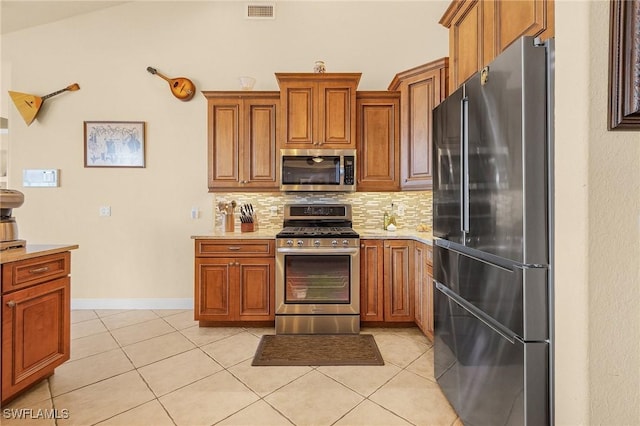 kitchen featuring stainless steel appliances, light tile patterned flooring, visible vents, and tasteful backsplash