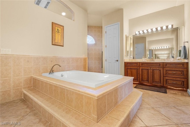 full bath featuring a relaxing tiled tub, visible vents, vanity, and tile patterned floors