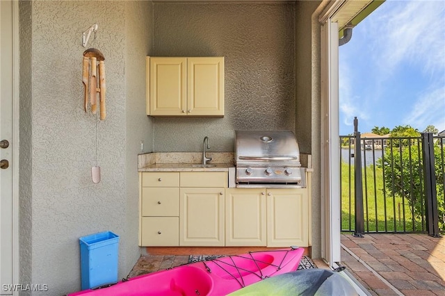 view of patio featuring an outdoor kitchen, grilling area, and a sink