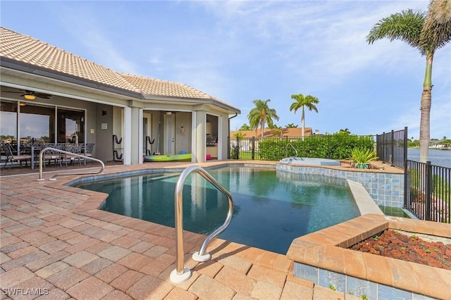 view of swimming pool featuring a patio, fence, and a pool with connected hot tub