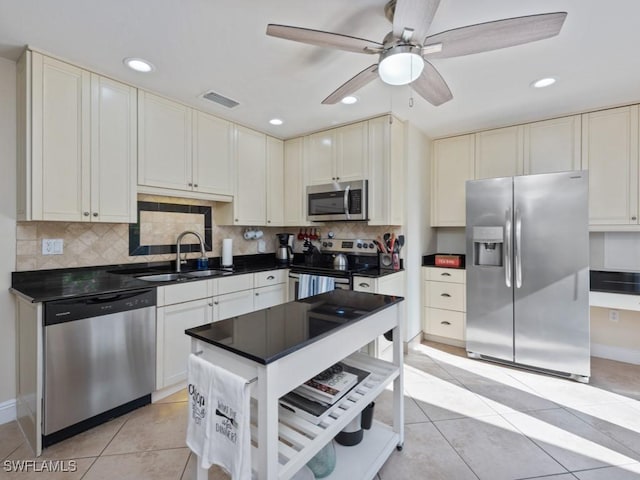 kitchen with a sink, stainless steel appliances, a ceiling fan, recessed lighting, and decorative backsplash