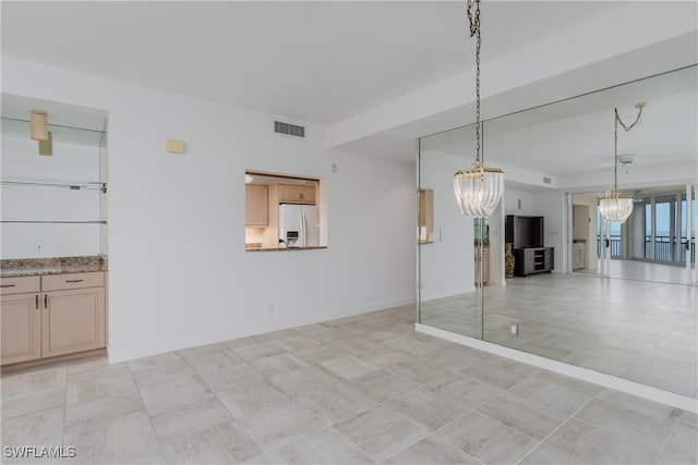 unfurnished living room featuring a chandelier and light tile patterned floors